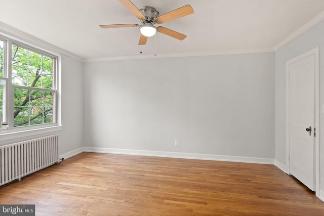 empty room featuring radiator, light wood-type flooring, baseboards, crown molding, and a ceiling fan