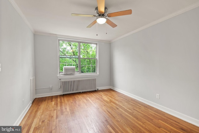 empty room featuring radiator, wood finished floors, a ceiling fan, ornamental molding, and baseboards