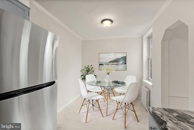 dining room with radiator heating unit, crown molding, and baseboards