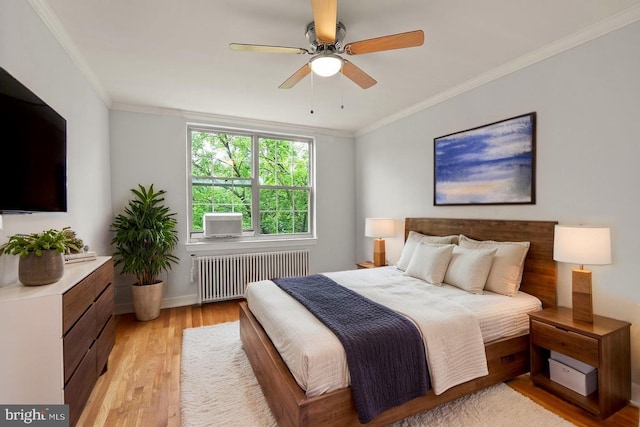 bedroom featuring radiator heating unit, light wood-style floors, ornamental molding, and a ceiling fan
