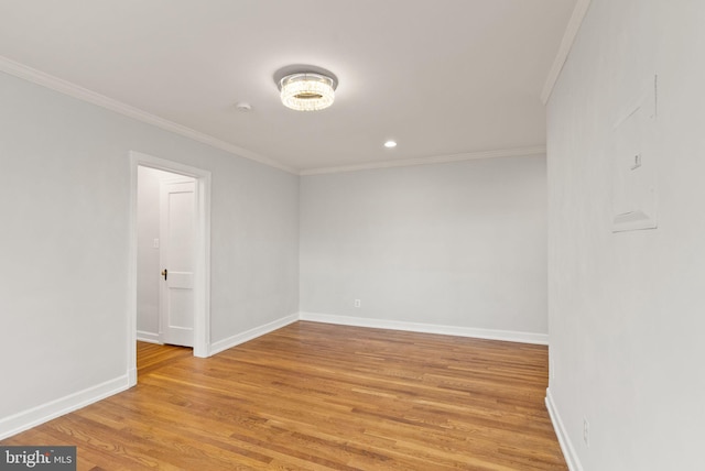 empty room with ornamental molding, light wood finished floors, baseboards, and recessed lighting