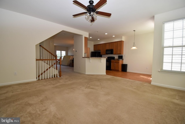 10020 Iron Pointe Dr Unit 9D, Millsboro, DE 19966 - unfurnished living room featuring light carpet, baseboards, ceiling fan, stairway, and recessed lighting