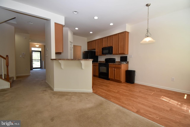 10020 Iron Pointe Dr Unit 9D, Millsboro, DE 19966 - kitchen featuring black appliances, a breakfast bar, a peninsula, baseboards, and recessed lighting