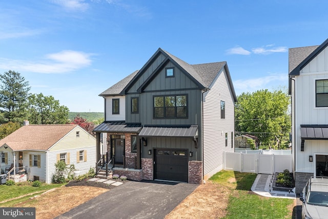 modern farmhouse with board and batten siding, a garage, driveway, fence, and brick siding
