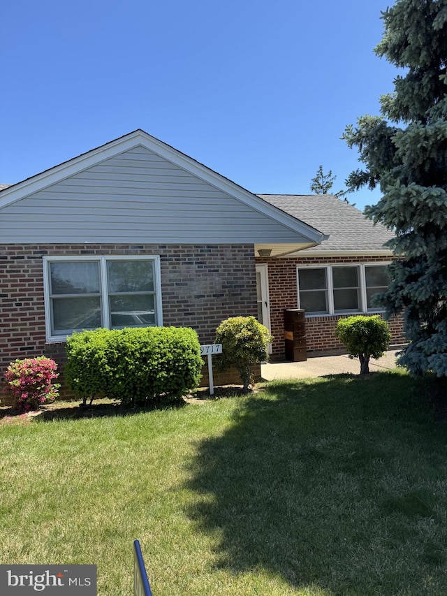 view of front of house featuring brick siding and a front yard
