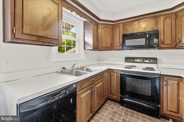 kitchen featuring black appliances, a sink, brown cabinets, and light countertops