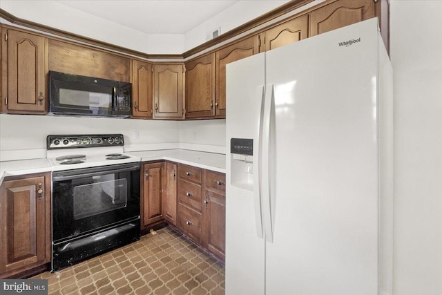 kitchen with white refrigerator with ice dispenser, black microwave, range with electric stovetop, light countertops, and brown cabinetry