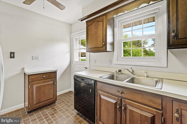 kitchen featuring black dishwasher, a sink, baseboards, light countertops, and a ceiling fan