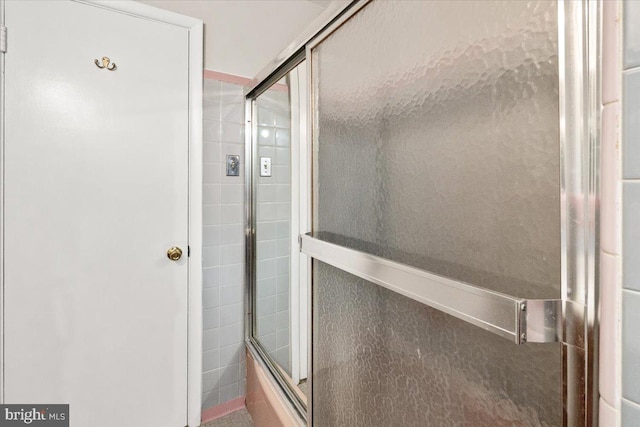 bathroom with bath / shower combo with glass door