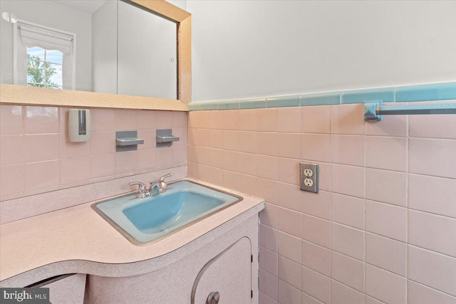 bathroom with tile walls, vanity, and backsplash