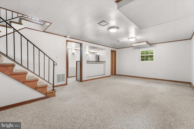 basement featuring carpet, stairway, baseboards, and freestanding refrigerator