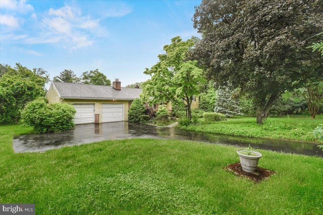 view of grassy yard featuring a garage