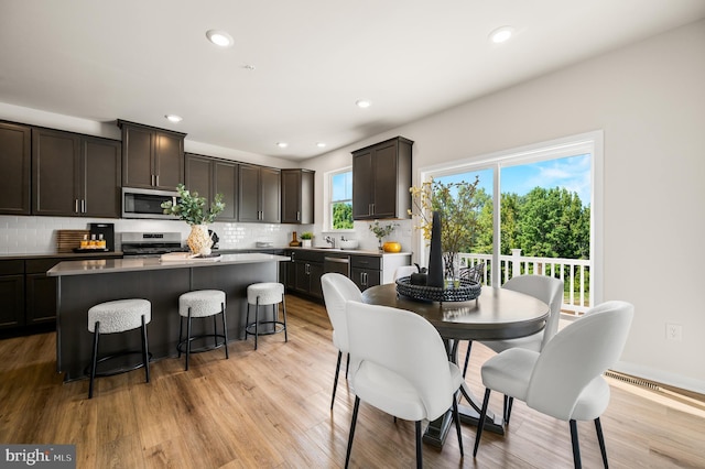 dining space featuring recessed lighting and light wood-style flooring