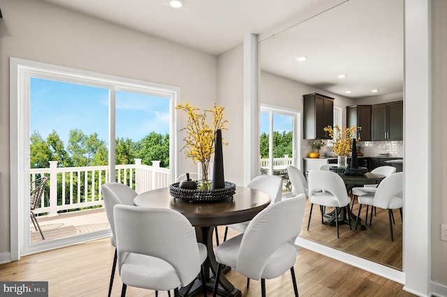 dining space with light wood finished floors and recessed lighting
