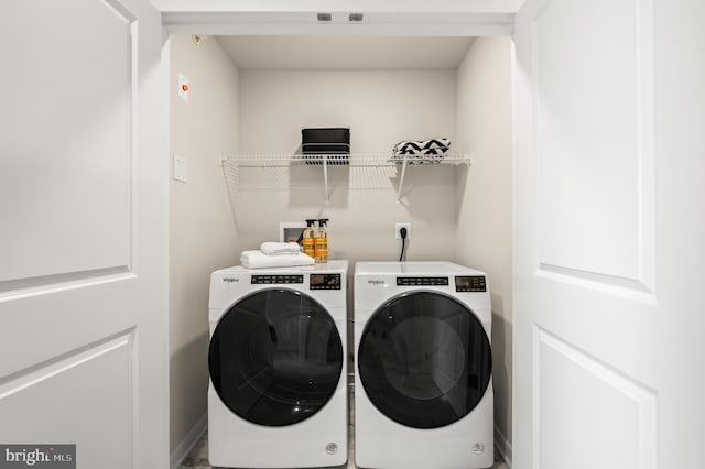 clothes washing area featuring independent washer and dryer and baseboards