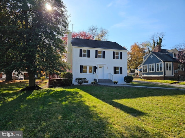 view of front of home featuring a chimney and a front lawn