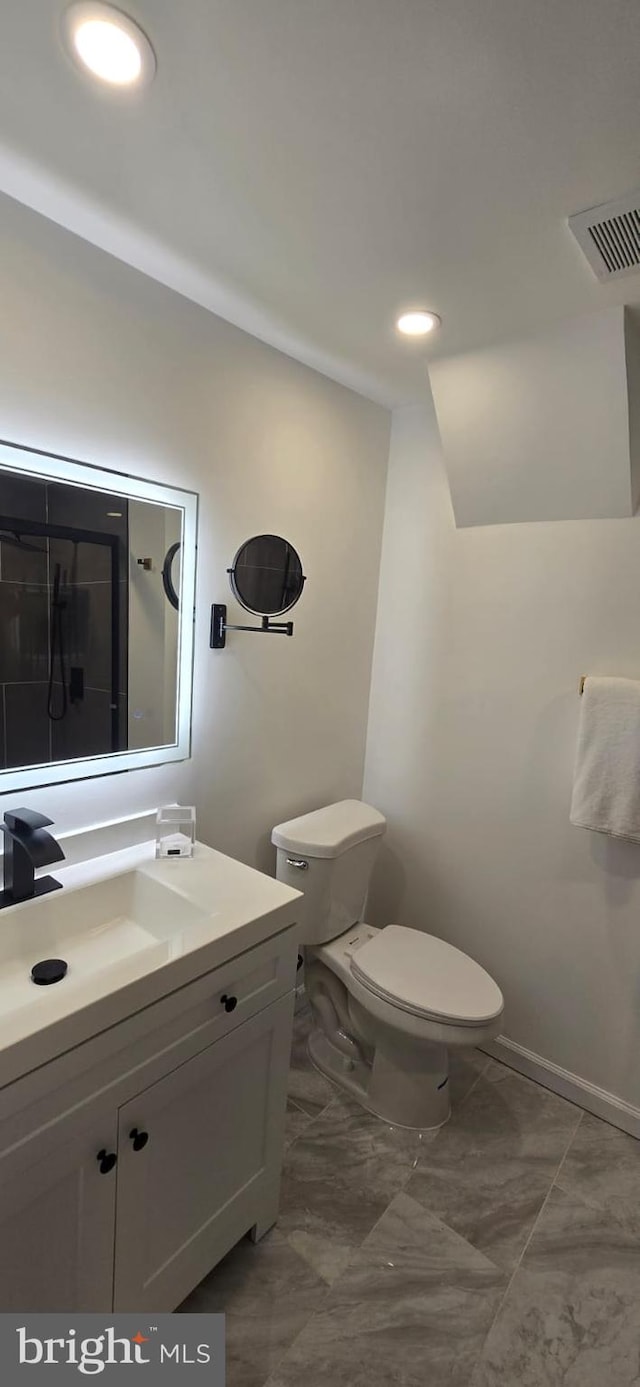 bathroom with toilet, vanity, and baseboards