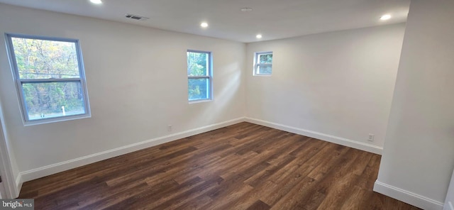 unfurnished room featuring dark wood finished floors, baseboards, and recessed lighting