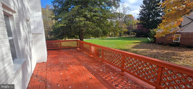 wooden deck featuring a lawn