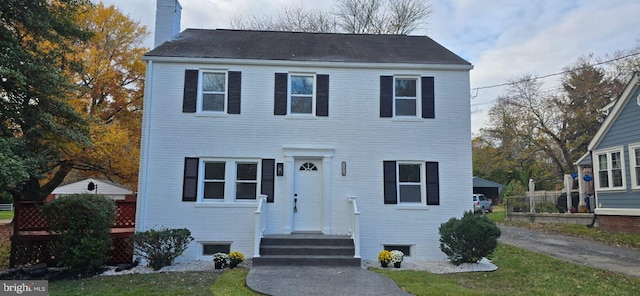 view of front of property featuring a chimney and roof with shingles