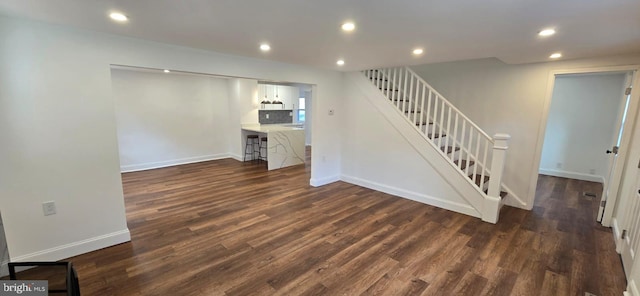 basement featuring dark wood finished floors, stairs, recessed lighting, and baseboards