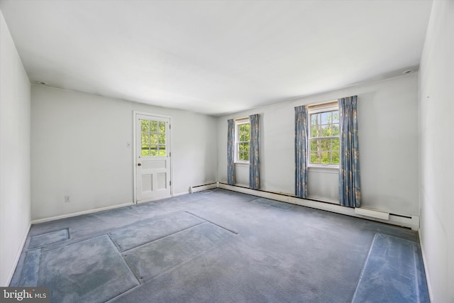 empty room featuring a baseboard heating unit, carpet, and baseboards