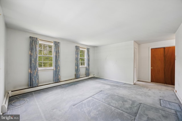 carpeted empty room featuring baseboard heating and baseboards