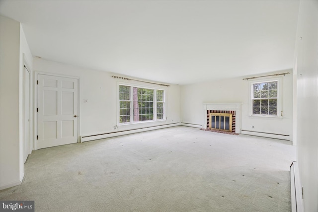 unfurnished living room featuring a baseboard heating unit, plenty of natural light, and a fireplace