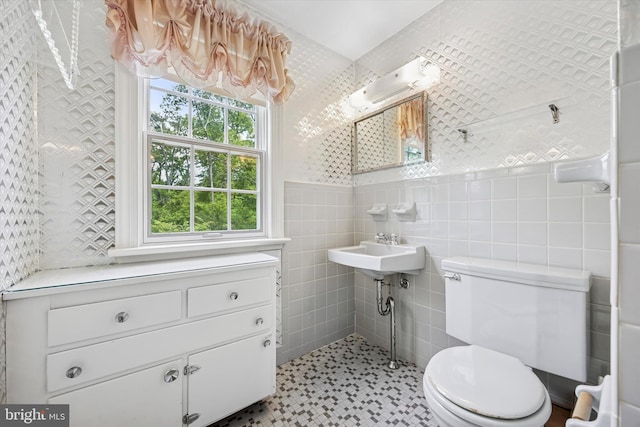 bathroom featuring toilet and tile walls