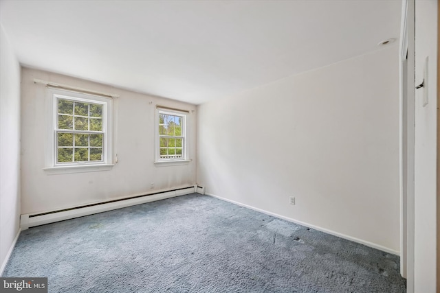 unfurnished room with a baseboard heating unit, carpet floors, and baseboards