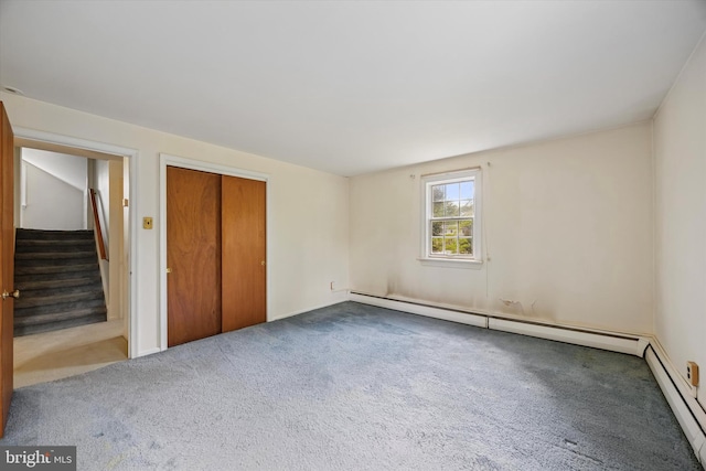 unfurnished bedroom featuring carpet, a baseboard heating unit, a closet, and a baseboard radiator