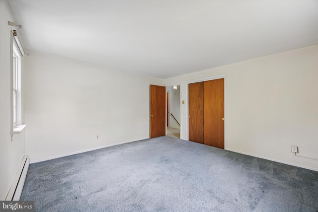 unfurnished bedroom featuring a baseboard radiator, carpet flooring, a closet, and baseboards