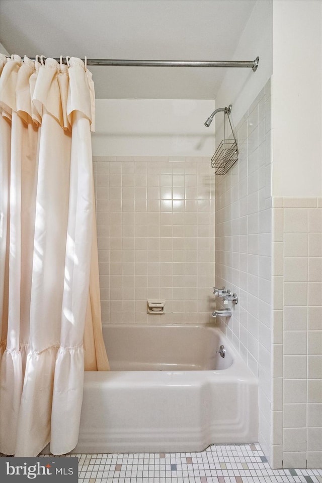 full bath featuring tile patterned floors, shower / bathtub combination with curtain, and tile walls