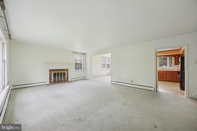 unfurnished living room featuring baseboard heating, a baseboard heating unit, and a brick fireplace