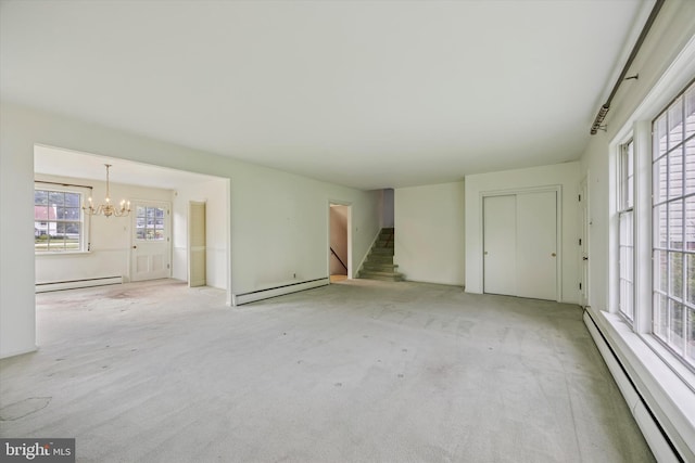 unfurnished living room featuring a baseboard radiator, a chandelier, and carpet