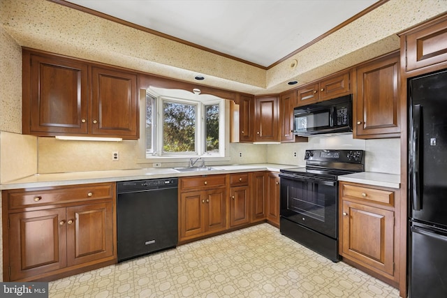 kitchen featuring black appliances, light countertops, ornamental molding, brown cabinets, and a sink