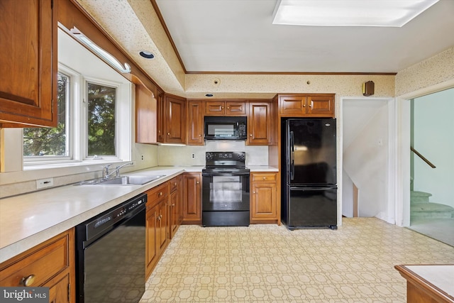 kitchen featuring black appliances, a sink, light countertops, brown cabinets, and light floors