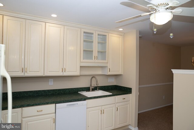 kitchen featuring dishwasher, a sink, recessed lighting, dark countertops, and carpet flooring
