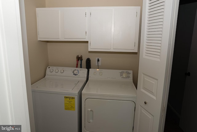 washroom with cabinet space and washer and dryer
