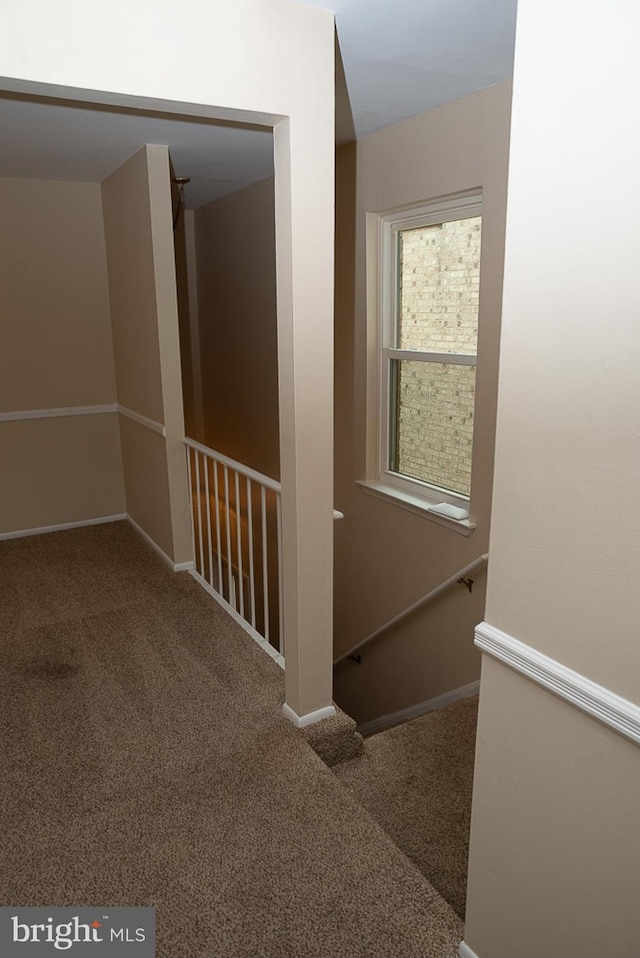 hall with carpet, an upstairs landing, and baseboards