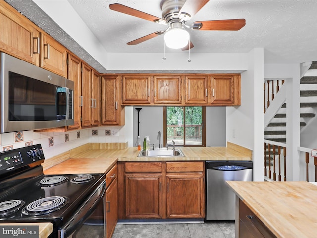 13833 Palmer House Way Unit 32-233, Silver Spring, MD 20904 - kitchen featuring stainless steel appliances, a sink, butcher block counters, brown cabinets, and a textured ceiling