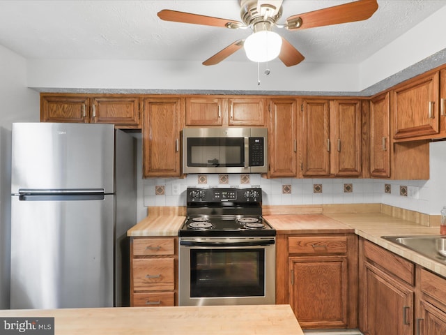 13833 Palmer House Way Unit 32-233, Silver Spring, MD 20904 - kitchen with stainless steel appliances, brown cabinets, ceiling fan, backsplash, and a sink