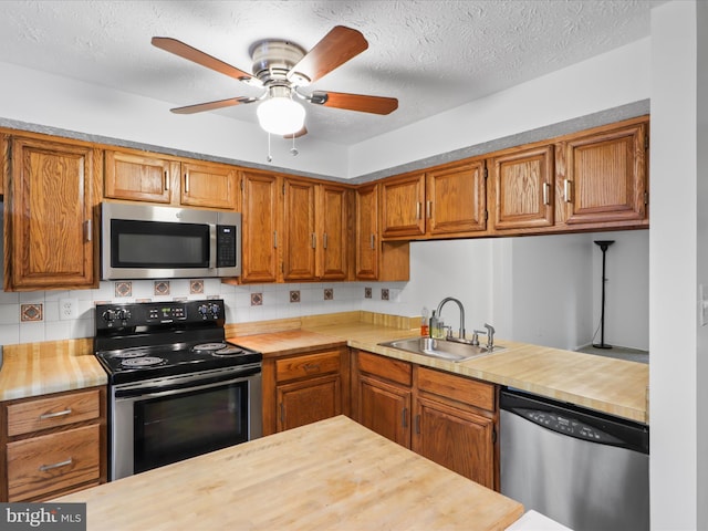 13833 Palmer House Way Unit 32-233, Silver Spring, MD 20904 - kitchen with appliances with stainless steel finishes, a sink, wood counters, brown cabinets, and a ceiling fan