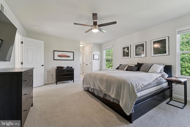 bedroom featuring light carpet, baseboards, and a ceiling fan