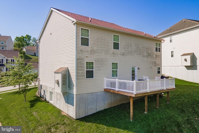rear view of property featuring a yard and a wooden deck
