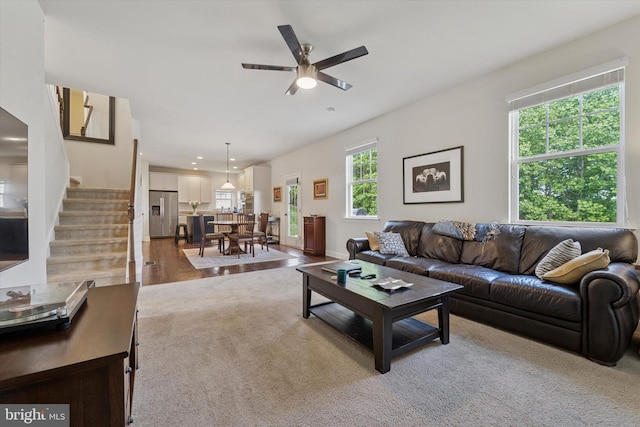 carpeted living area featuring stairway, ceiling fan, and recessed lighting