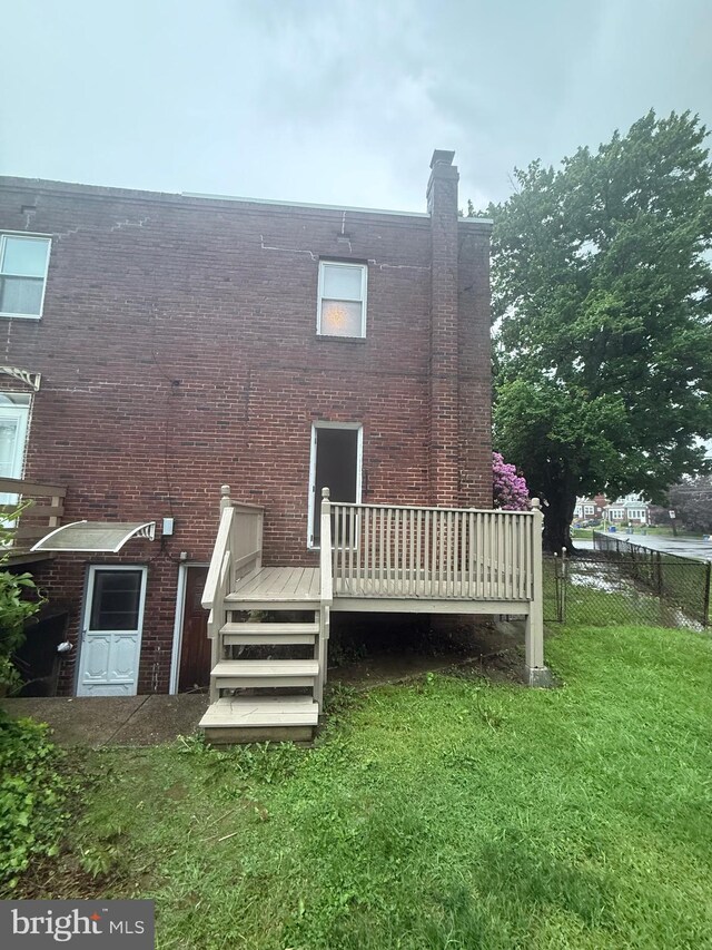 1113 Faunce St, Philadelphia, PA 19111 - back of property with a wooden deck, brick siding, and a chimney