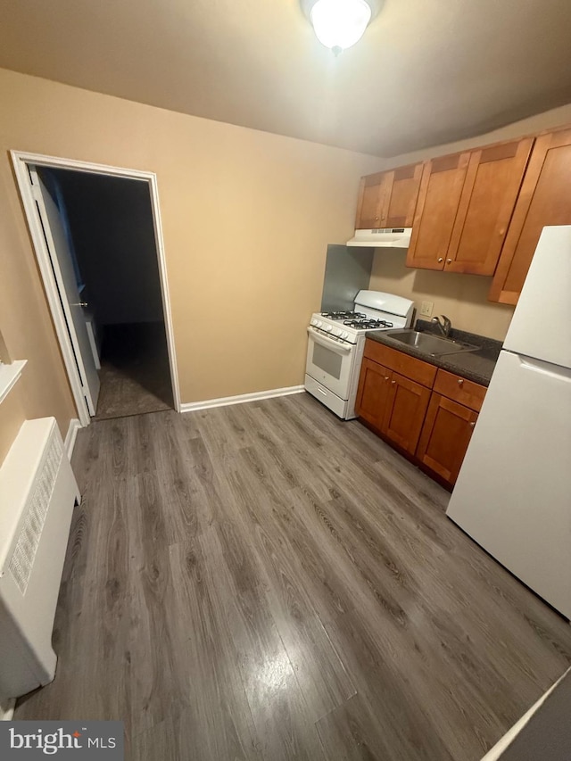 1113 Faunce St, Philadelphia, PA 19111 - kitchen featuring white appliances, a sink, under cabinet range hood, wood finished floors, and dark countertops