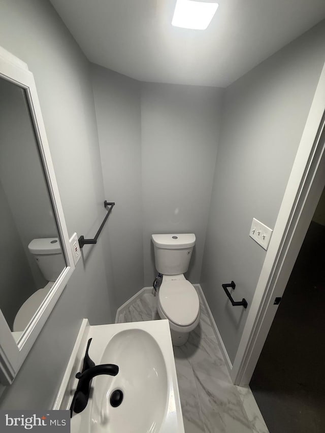 1113 Faunce St, Philadelphia, PA 19111 - half bath with toilet, marble finish flooring, a sink, and baseboards