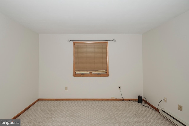 unfurnished room with a baseboard heating unit, carpet floors, and baseboards